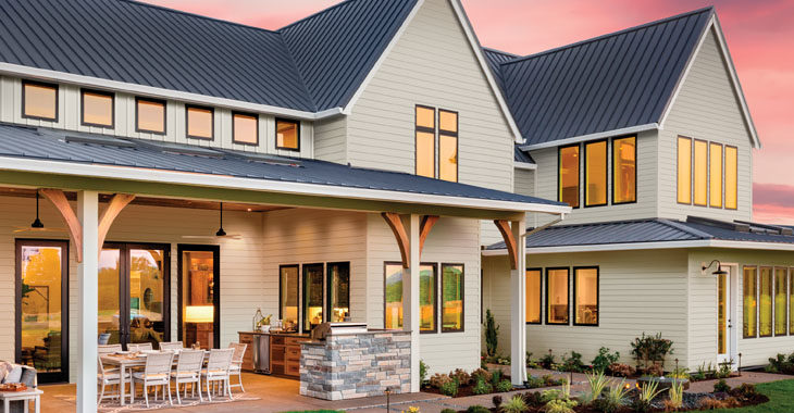 A beautiful suburban home with a porch shown at sunset