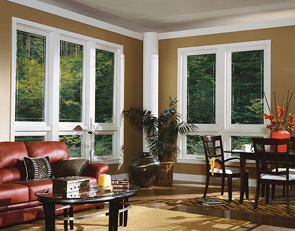 The living area of a home with a dining table and walls of gorgeous casement windows