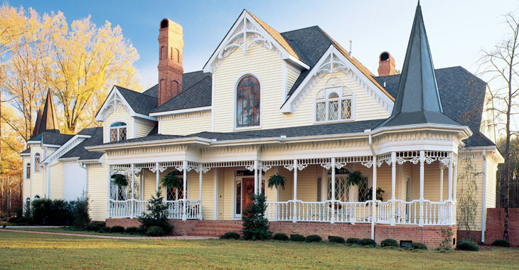 A large suburban home with yellow siding and intricate trimwork