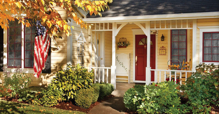 A suburban American home with a front porch and flag outside