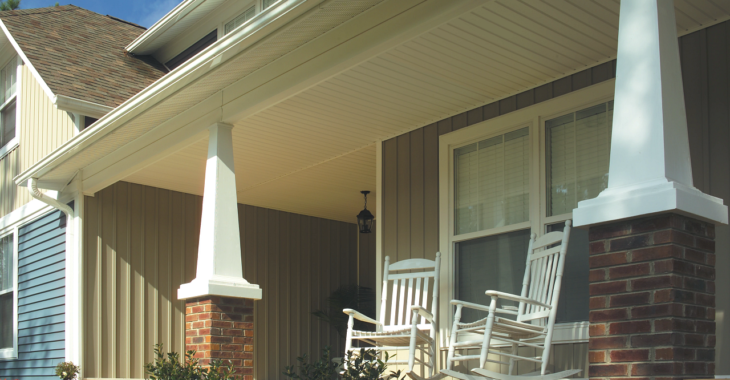 porch with rocking chairs on home with stone pillars and large windows