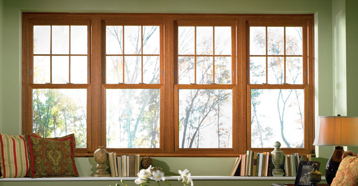 four wood-clad single-hung windows in a cozy reading nook